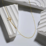 14k gold filled necklace with a cut-out birth flower pendant on a white architectural background